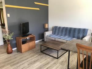 Duncan Motel في دانكن: غرفة معيشة مع أريكة وتلفزيون