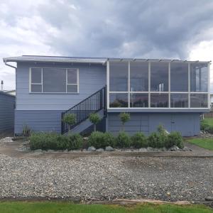 a white house with a staircase in front of it at Riverton Cottage 2 Bedroom Close to beach in Riverton