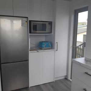 a kitchen with a refrigerator and a microwave at Riverton Cottage 2 Bedroom Close to beach in Riverton