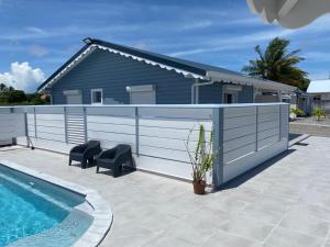 a swimming pool with a fence next to a house at Domaine de Dugay in Beauregard