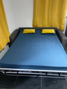 a blue bed with two yellow pillows on it at Domaine de Dugay in Beauregard