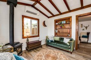 a living room with a green couch and a fireplace at JT Cottage in Yucca Valley