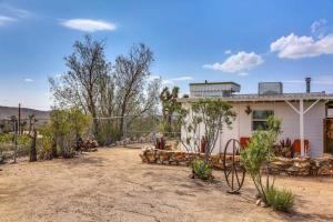 een huis in de woestijn met een hek bij JT Cottage in Yucca Valley