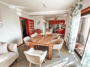a kitchen and dining room with a wooden table and chairs at Casa Riamar in São Jacinto