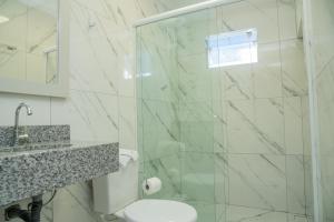 La salle de bains est pourvue d'une douche, de toilettes et d'un lavabo. dans l'établissement Suítes 590, à Penha