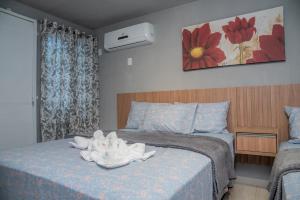 1 dormitorio con 1 cama con toallas en Suítes 590, en Penha