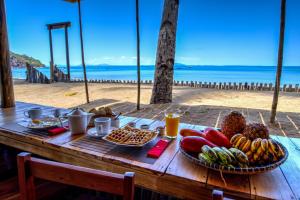 - une table en bois avec de la nourriture au-dessus de la plage dans l'établissement Swisscocobeach, à Nosy Be