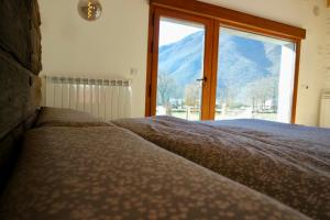 a bedroom with a large window with a mountain view at El Parreiro VUT-LE-610 Dúplex in Villablino