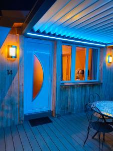 d'une terrasse avec une table et une lumière bleue. dans l'établissement Au-Doux-Altic chalet romantique avec JACUZZI ET SAUNA, à Métabief