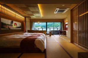 a bedroom with a large bed and a large window at Aburaya Tousen in Yamanouchi
