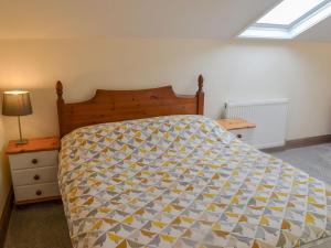 a bedroom with a bed with a quilt on it at Rose Cottage - Uk41345 in Cromer