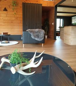 una sala de estar con una mesa de cristal con cuernos. en Hooting Owl private ski chalet, en Niseko