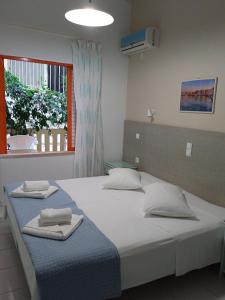 a bedroom with a large bed with towels on it at Ilona Apartments Chania in Kato Daratso