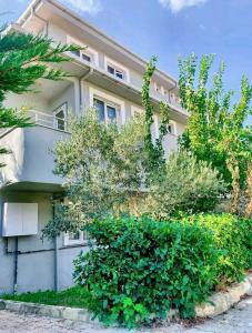 a white building with bushes in front of it at Forest villa- 5 minutes from the airport in Arnavutköy