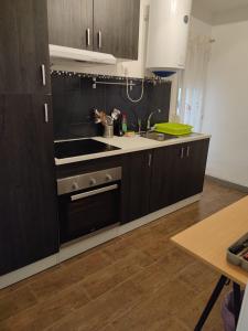 a kitchen with wooden cabinets and a stove top oven at Be like home Texas in Alcalá de Henares