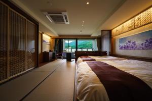 ein Hotelzimmer mit einem großen Bett und einem Schreibtisch in der Unterkunft Aburaya Tousen in Yamanouchi