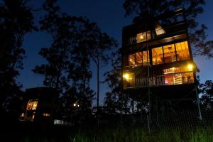 a tall building at night with lights at Gold Coast Tree Houses in Neranwood