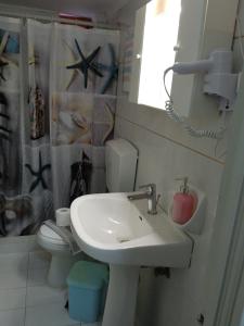 La salle de bains est pourvue d'un lavabo et de toilettes. dans l'établissement Ilona Apartments Chania, à Kato Daratso