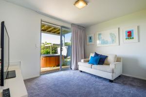 a living room with a couch and a sliding glass door at Palm Ridge - near Onetangi & Palm Beach in Palm Beach