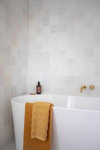 a white bath tub with a brown towel on it at Sunnymead Hotel in Aireys Inlet