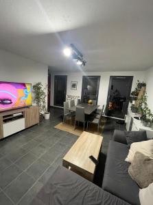 een woonkamer met een bank en een flatscreen-tv bij Chambre chez l’habitant à Strasbourg in Straatsburg
