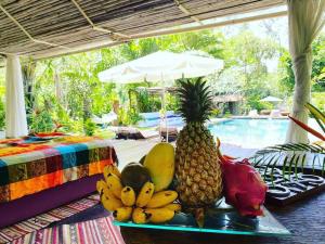 a tray of fruit on a table next to a pool at Maddekehaoo Eco Mansion in Ko Chang
