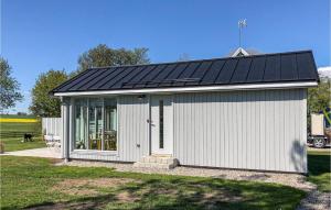 a small white building with a solar roof at Lovely Home In Skivarp With Wifi in Skivarp +19 photos