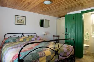 1 dormitorio con cama y puerta verde en Cobblers Cottage Creggan, en Greencastle