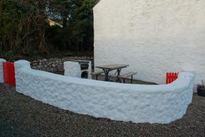 a large white boat sitting next to a table at Cobblers Cottage Creggan in Greencastle
