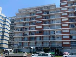 a large apartment building with cars parked in front of it at Casa Nostrum Priceless View Central Location 3BR 3BA in Punta del Este