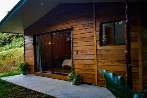 a wooden cabin with a large glass door at Cabañas Lys in Monteverde Costa Rica