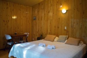 a bedroom with a bed with two towels on it at Cabañas Lys in Monteverde Costa Rica