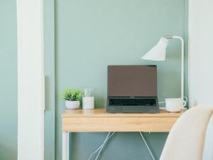 a laptop computer sitting on a desk with a lamp at ゲストハウスVACILANDO in Chitose