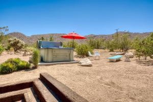 a patio with an umbrella and a table and chairs at Desert Dusk in Joshua Tree