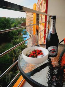 a bowl of strawberries and a bottle of beer on a table at Квартира in Ban Bo Sai Klang