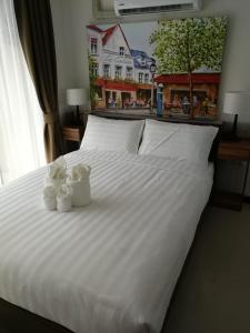 a white bed with two white flowers on it at Квартира in Ban Bo Sai Klang