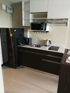 a small kitchen with a sink and a refrigerator at Квартира in Ban Bo Sai Klang