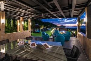 Blick auf eine Terrasse mit einem Tisch und Stühlen in der Unterkunft Magic suites in Strand Choeng Mon