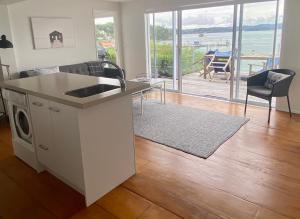 a kitchen and living room with a view of the ocean at Wharf View in Russell