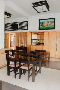 ein Esszimmer mit Holztischen und -stühlen in der Unterkunft SM Bromo Hotel in Probolinggo