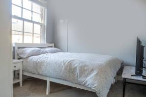 a bedroom with a bed and a television and a window at No6 - Beverley - Elegant Townhouse - Central location in Beverley