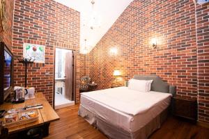 - une chambre avec un mur en briques, un lit et une table dans l'établissement 墾丁勿忘我城堡莊園, à Hengchun Old Town