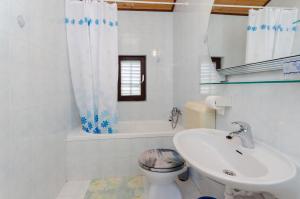 Apartments Ljubica J في لوبار: حمام أبيض مع حوض ومرحاض