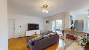 uma sala de estar com um sofá e uma mesa em Live Like a Local Stylish 2BR with Balcony & Parking em Saint-Denis