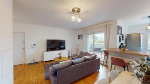a living room with a couch and a table at Live Like a Local Stylish 2BR with Balcony & Parking in Saint-Denis