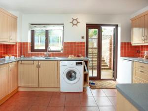 a kitchen with a washing machine in the middle at The Seashell in Dawlish Warren