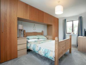 a bedroom with a bed with a wooden headboard at The Seashell in Dawlish Warren
