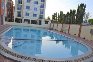 a large blue swimming pool in front of a building at Mtwapa HomeStay 3br Apartments in Mombasa