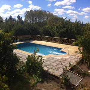 a swimming pool with a wooden bridge over it at Cabaña Quillón El Campito in Quillón