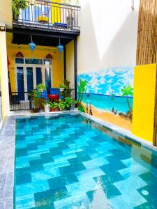 uma piscina no meio de uma casa com praia em An Bang Sea Adventure Homestay Hoi An em Hoi An